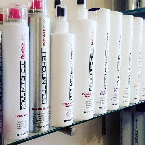 An shelf of Paul Mitchell products aligned neatly on a shelf.